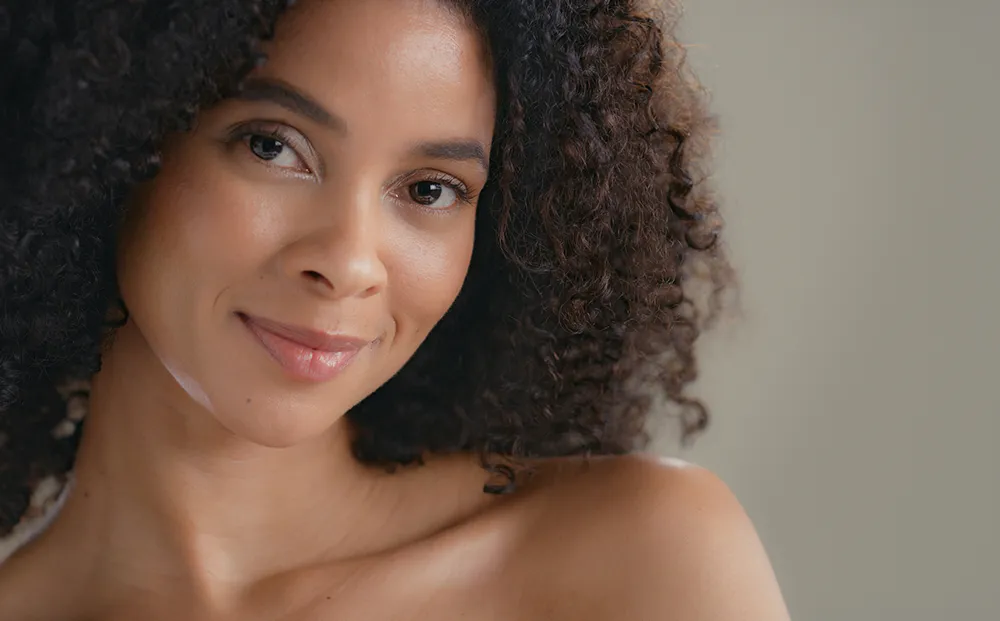 Curly hair woman smiling| Facelift | Dr. Nikolov